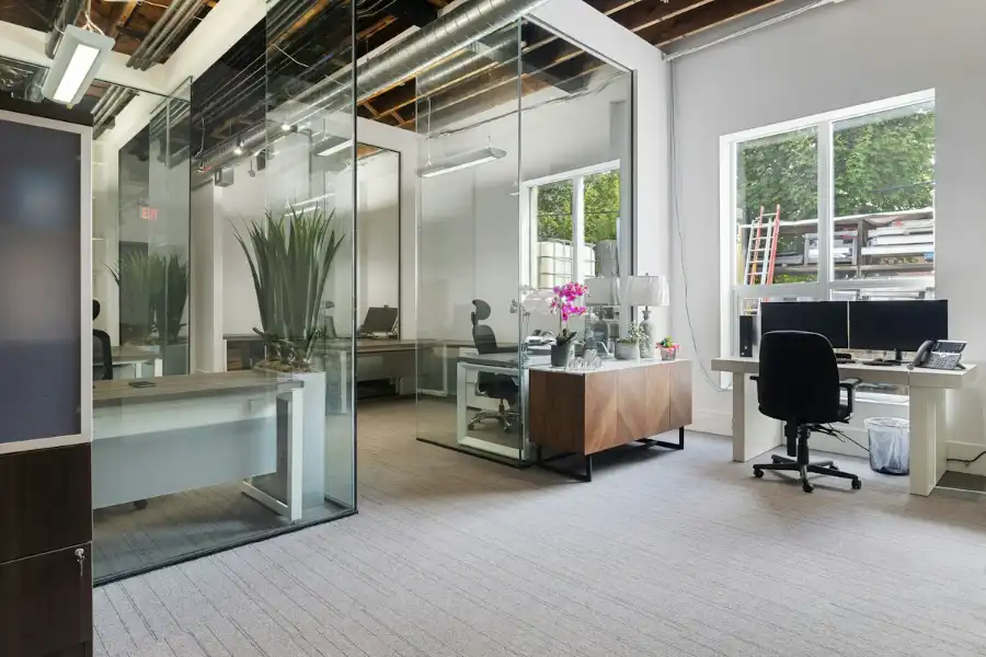 A bright office with desks, chairs and glass walls